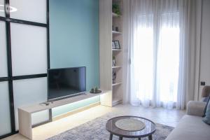 uma sala de estar com uma televisão, um sofá e uma mesa em CasaTu Αpartments em Komotini