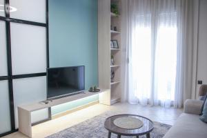 a living room with a tv and a couch and a table at CasaTu Αpartments in Komotini