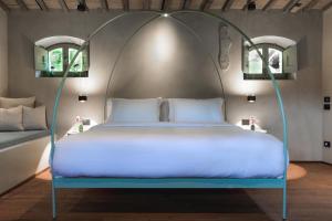 a bed with an iron canopy in a room at Vocabolo Moscatelli in Calzolaro