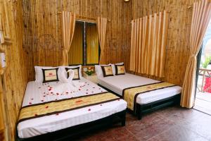 two beds in a room with a window at Hang Múa Lotus Homestay in Ninh Binh +37 photos