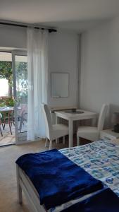 ヘルツェグ・ノヴィにあるApartmani Milosevicのベッドルーム1室(ベッド1台、テーブル、椅子付)