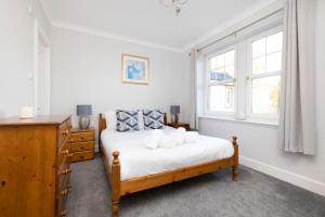 a bedroom with a bed and two windows at JOIVY Modern flat with free parking in Edinburgh