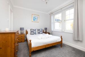 a bedroom with a bed and two windows at ALTIDO Modern flat with free parking in Edinburgh