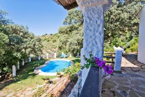 um jardim com uma piscina e uma cerca em Villa La Manzanilla Rocabella em El Chorro
