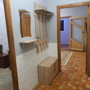 um quarto com um armário de madeira e um espelho em Уютная квартира в центре города. em Aktau