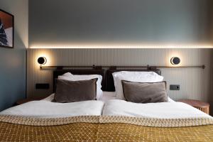 um quarto com 2 camas com lençóis brancos e almofadas em Elite Stadshotellet Karlstad, Hotel & Spa em Karlstad