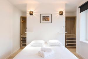 Duas camas num quarto com paredes e prateleiras brancas em Le Spacieux de Dizier em Nancy