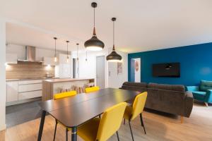 uma cozinha e sala de estar com uma mesa e cadeiras amarelas em Le Spacieux de Dizier em Nancy