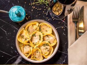 a bowl of pasta with dumplings on a table at Sofitel Luxembourg Europe in Luxembourg