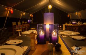a table with purple candles on top of it at Ahaspokuna by Eco Team in Belihul Oya