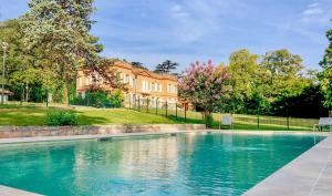 a swimming pool in front of a house at Domaine de Montjoie - Toulouse - BW Premier Collection in Ramonville-Saint-Agne