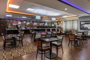 a restaurant with tables and chairs and a bar at Best Western Plus North Odessa Inn & Suites in Odessa