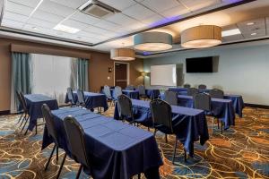 a conference room with blue tables and chairs and a screen at Best Western Plus North Odessa Inn & Suites in Odessa