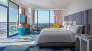 a hotel room with a large bed and a balcony at Lake Nona Wave Hotel in Orlando