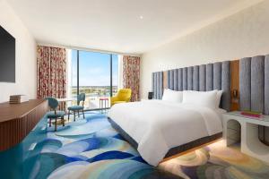 a hotel room with a large bed and a desk at Lake Nona Wave Hotel in Orlando