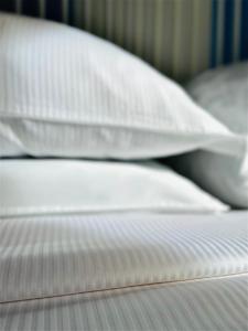 Una cama con sábanas blancas y almohadas. en Lagoon Secret Venice en Venecia
