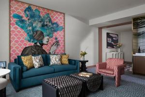 オーランドにあるLake Nona Wave Hotelのリビングルーム(青いソファ、絵画付)
