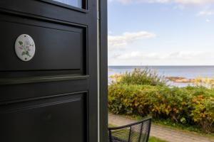 a black door with a door knob and a chair at Allinge Badehotel in Allinge