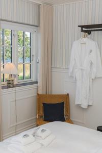 a bedroom with a bed and a robe hanging on a wall at Allinge Badehotel in Allinge