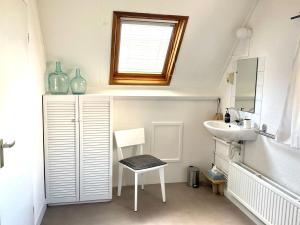 a small bathroom with a sink and a mirror at Zilt Noordwijk in Noordwijk aan Zee