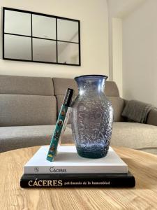 Un vaso blu seduto sopra un libro su un tavolo di Apartamento Turístico Clavellinas IV a Cáceres