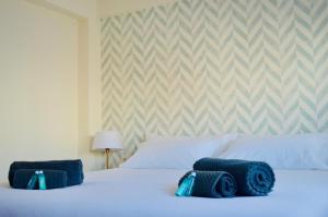 een slaapkamer met een bed met blauwe handdoeken bij Apartamento Turístico Clavellinas IV in Cáceres