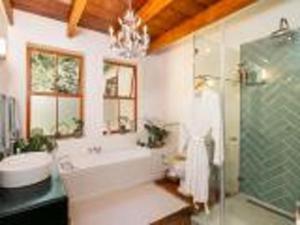 a bathroom with a tub and a sink and a shower at Ganzvlei Manor Cottage in Knysna