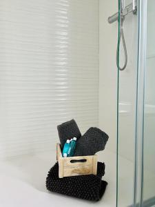 a bathroom with a glass shower and a black chair at Apartamento Turístico Clavellinas IV in Cáceres