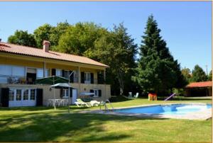 a large house with a swimming pool in the yard at Quinta das Marinhas de Paredes de Coura in Paredes de Coura