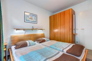 een slaapkamer met 2 bedden en een houten hoofdeinde bij Villa Regina Maris Fewo Lachmöwe in Bansin