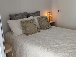 een slaapkamer met een bed met witte lakens en kussens bij Salitre Suite 2 in Tacoronte