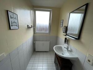 a white bathroom with a sink and a window at City-Wohnen in Düren im Boho-Style in Düren - Eifel