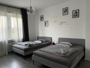 2 Betten in einem Schlafzimmer mit einer Wand mit Unterschrift in der Unterkunft Ruhrpott Apartment Zentral in Herne