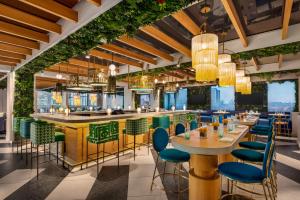 a restaurant with tables and chairs and a bar at Lake Nona Wave Hotel in Orlando