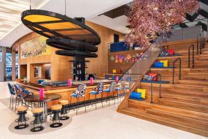 a restaurant with a bar with blue chairs and stairs at Lake Nona Wave Hotel in Orlando