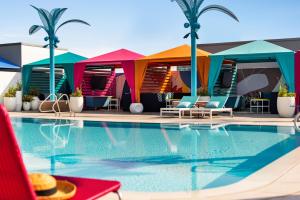 a pool at a hotel with colorful huts at Lake Nona Wave Hotel in Orlando