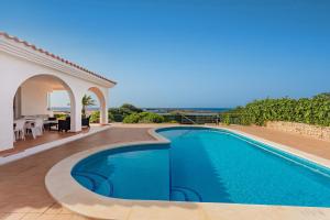 a villa with a swimming pool and a patio at Binicasal in Sant Lluis