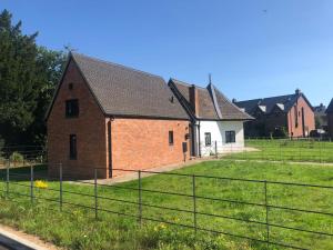 a large brick building with a grass field in front at The Dairy - Contemporary 1 bedroom cottage 