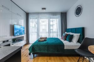 sypialnia z łóżkiem z zielonym kocem i telewizorem w obiekcie Emihouse CityVibe Apartments w mieście Rzeszów