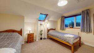 a bedroom with two beds and a window at Jaw-Dropping Beach House In Anglesey in Benllech