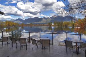 a patio with tables and chairs and a view of a lake at Ninepipes Lodge in Polson