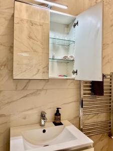 a bathroom with a white sink and a cabinet at white home near Linate in Segrate