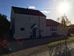 a white house with a red roof at Luxury Tranquil Cottage with Hot tub, Log burner and Jacuzzi Bath in Alford