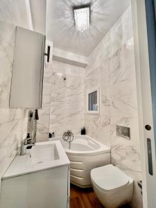 y baño con bañera, aseo y lavamanos. en white home near Linate en Segrate