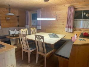 eine Küche und ein Esszimmer mit einem Tisch und Stühlen in der Unterkunft Kuschelhüsli Garfrescha Wohnung Madrisella in Aussersiggam