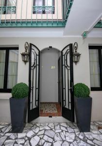una puerta de entrada de una casa con dos zonas verdes en Hôtel Eiffel Rive Gauche en París