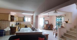 eine Küche und ein Wohnzimmer mit einem Tisch und einer Treppe in der Unterkunft Kounis Villa in Chalkida