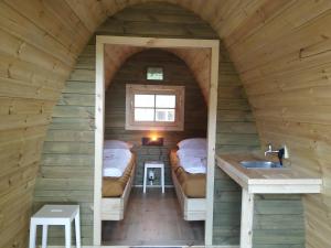 um pequeno quarto com 2 camas e um lavatório em Luxe glamping "De Steenuil" met sauna em Volkel