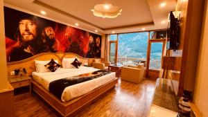 a bedroom with a king sized bed with a painting on the wall at Smuggler Resort in Manāli