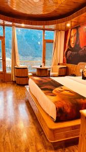 a bedroom with a large bed and a large window at Smuggler Resort in Manāli